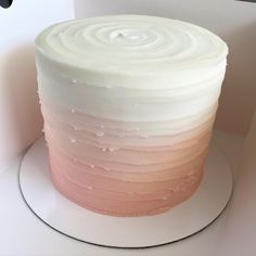 a cake with white frosting and pink icing