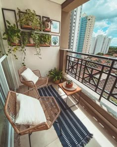 two wicker chairs sitting on top of a balcony next to a table and potted plants