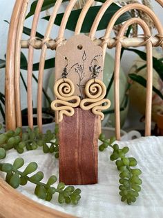 wooden earrings with spiral designs on them sitting on a chair