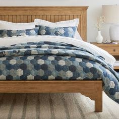 a bed with blue and white bedspread in a bedroom next to two nightstands