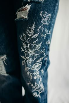 a pair of jeans with white flowers on them