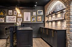 the bar is decorated in black and gold with pictures hanging on the wall above it