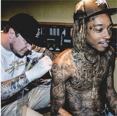 two men with tattoos sitting next to each other