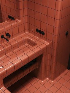 an orange tiled bathroom with two sinks and mirrors