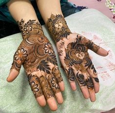 two hands with henna designs on them