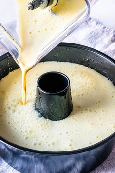 someone is pouring batter into a pan to make cheesecakes in the same bowl