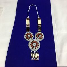 Southwestern seed bead and leather sunburst necklace. Three rounds of hand beaded motifs, attached to a 18" bead chain. A really pretty piece that honors the craftsmanship of the United States' oldest Americans. These  pieces, handcrafted by indigenous tribes, often as a major source of income, and often made as souvenirs, are incredibly well made and beautiful works of art.Necklaces of this style look amazing with a tee shirt, or a denim jacket. They also look stunning with a black turtleneck. Handmade White Beaded Southwestern Necklace, Southwestern Large Beads For Crafting, Southwestern White Hand-strung Beaded Necklace, White Southwestern Hand-strung Beaded Necklace, Southwestern Style White Beaded Necklace With Large Beads, Southwestern Brown Beaded Jewelry, Brown Beaded Southwestern Jewelry, Southwestern Style White Beaded Necklace As Gift, Southwestern Style Brown Beaded Jewelry