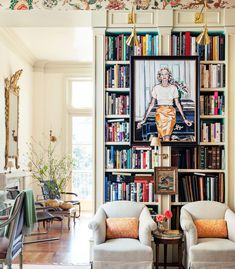 a living room filled with furniture and bookshelves covered in lots of bookcases