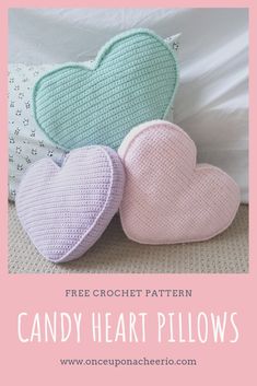 three crochet hearts sitting on top of a bed with the text free crochet pattern candy heart pillows