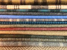 a pile of different colored plaid fabric on top of each other in various sizes and colors