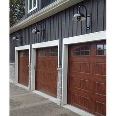 two brown garage doors in front of a gray building with white trim on the side