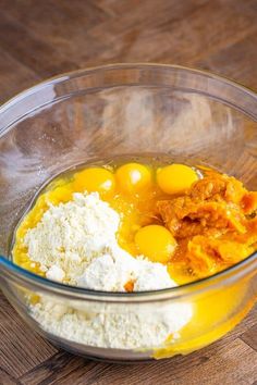 eggs and flour in a glass bowl on a wooden table