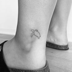 a small tattoo on the ankle of a woman's foot, depicting a turtle