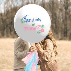 a man and woman holding a white balloon with the words stretch or angel? written on it