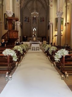 the aisle is lined with flowers and candles in front of an alter at a church