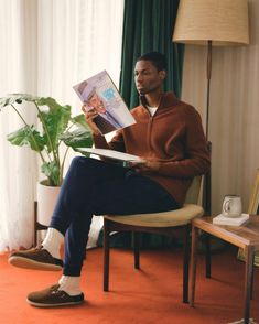 a man sitting in a chair reading a book