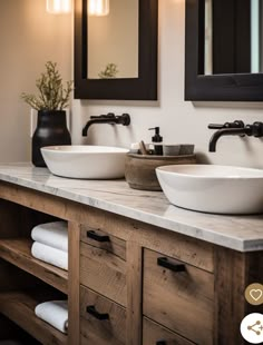 two white bowls sit on top of a wooden vanity