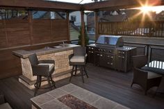 an outdoor grill and bar on a deck