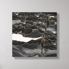 a black and gold painting on the wall in a room with a chair next to it