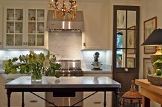 a kitchen with an island in the middle of it and lights hanging from the ceiling