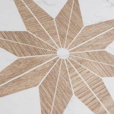 a white marble table top with a wooden star design