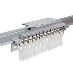 a close up of a metal rail with white curtain clips on the bottom and one end