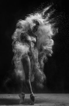 black and white photograph of a woman in ballet clothes with dust coming out of her body