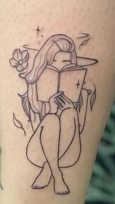 a woman with a book tattoo on her leg