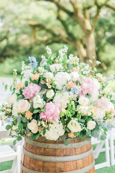 a wooden barrel filled with lots of flowers