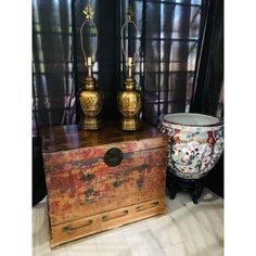 two vases sitting on top of an old trunk