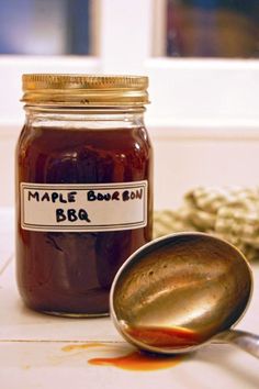 a spoon sitting next to a jar of maple bourbon bbq