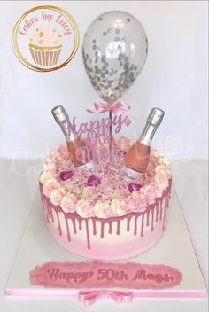 a birthday cake with pink icing and decorations