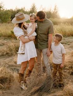 a man, woman and two children standing in tall grass