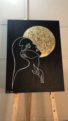 a black and gold painting with a woman's face on it