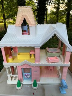 a pink doll house with furniture and accessories