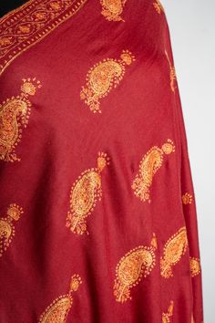 This deep red merino wool shawl features a stunning spread of Sozni hand-embroidered paisleys in golden hues, each pattern meticulously placed to showcase the masterful craftsmanship of Kashmiri artisans. The balanced use of intricate motifs against the bold red fabric lends an air of classic charm to the piece. Perfect for special occasions or as a statement wrap on chilly evenings, this shawl adds both warmth and sophistication to your look. The luxurious feel and exceptional embroidery make i Embroidered Rug, Scarf Jacket, Embroidered Handbag, Silk Carpet, Pashmina Shawl, Pashmina Scarf, Wool Shawl, Embroidered Bag, Embroidered Jacket