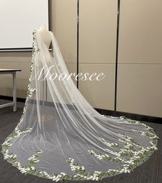 a wedding veil with white flowers on it