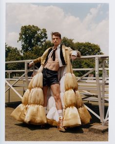 a man standing in front of a fence with his legs spread out and wearing shorts