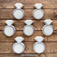 six wedding rings and ring boxes sitting on top of a wooden table