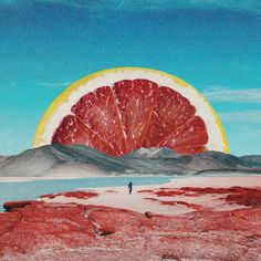 a man standing in front of a giant grapefruit on top of a desert