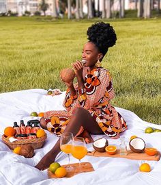 a woman sitting on top of a blanket next to oranges