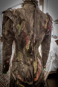 the back of a woman's shirt covered in mossy fabric and laces