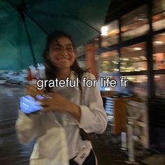 a woman holding an umbrella and cell phone in her hand with the caption grateful for life fr