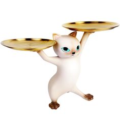 a white cat with blue eyes holding two plates on it's back while standing in the air