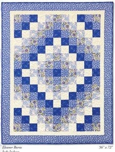 a blue and white quilt with an intricate design on the front, featuring squares in different colors