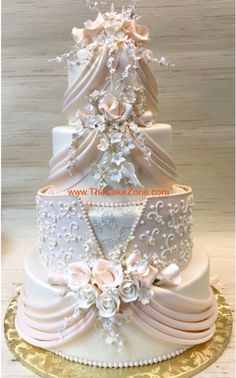 a three tiered wedding cake decorated with flowers and pearls