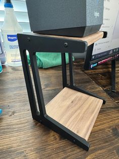 a wooden table topped with a computer monitor next to a speaker on top of it