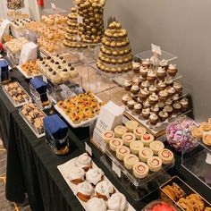 an assortment of cupcakes and pastries on display at a buffet or party