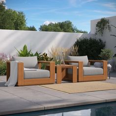 two wooden chairs sitting on top of a patio next to a swimming pool with plants