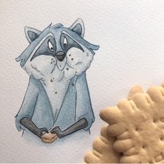 a cookie next to a drawing of a raccoon